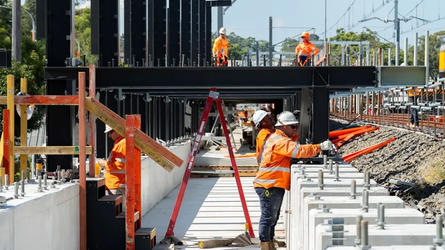 Various workers in high visibility gear working on the Bankstown Metro Platform 