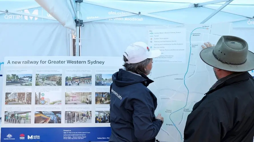 A Sydney Metro employee showing member of the community a map