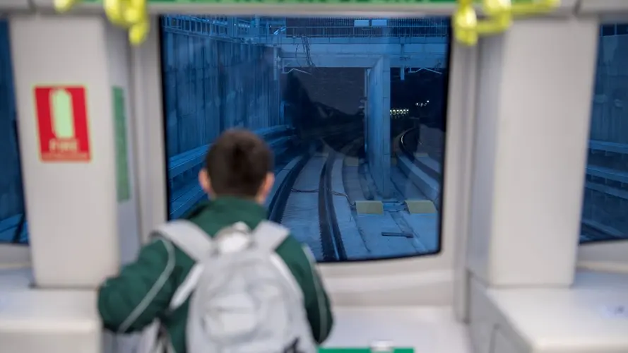 a young boy looking at the tracks from the newly opened city line metro 