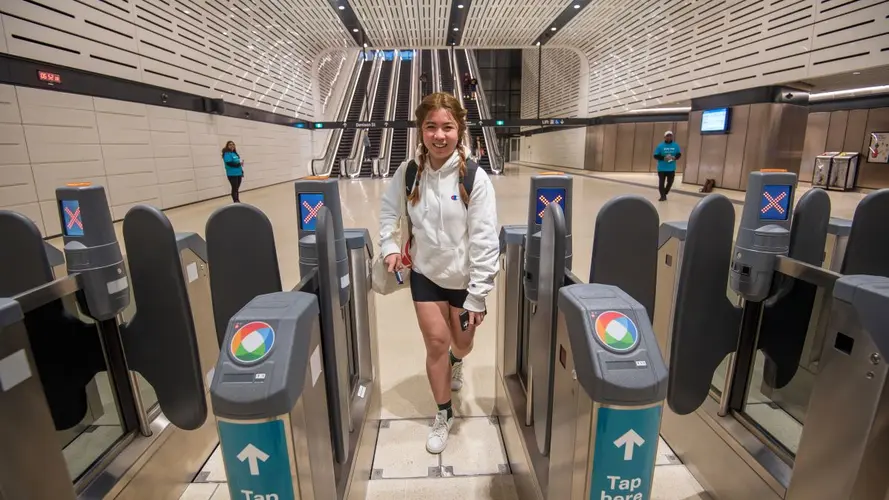 a young girl tapping in to enter the metro station 