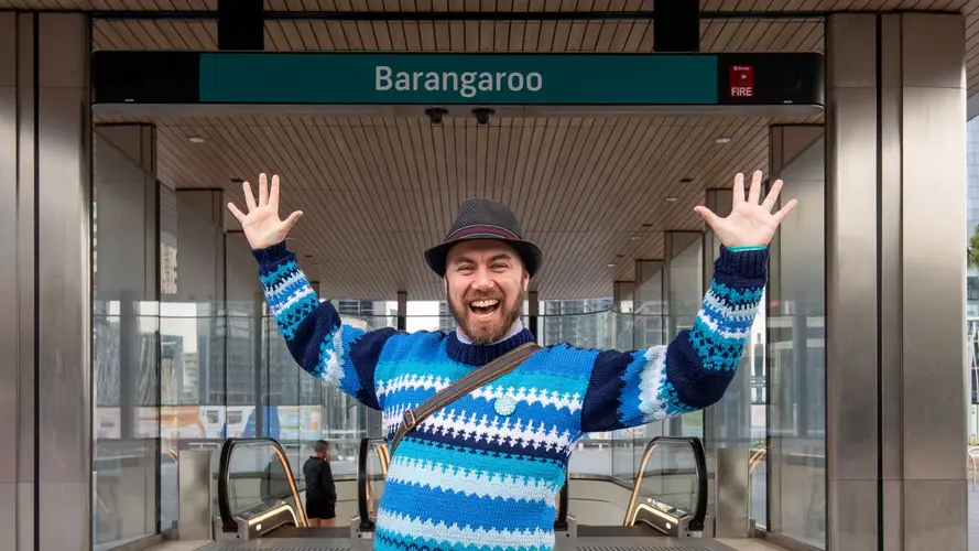 A man posing happily for the camera with hands up in the air at the City and Southwest Opening