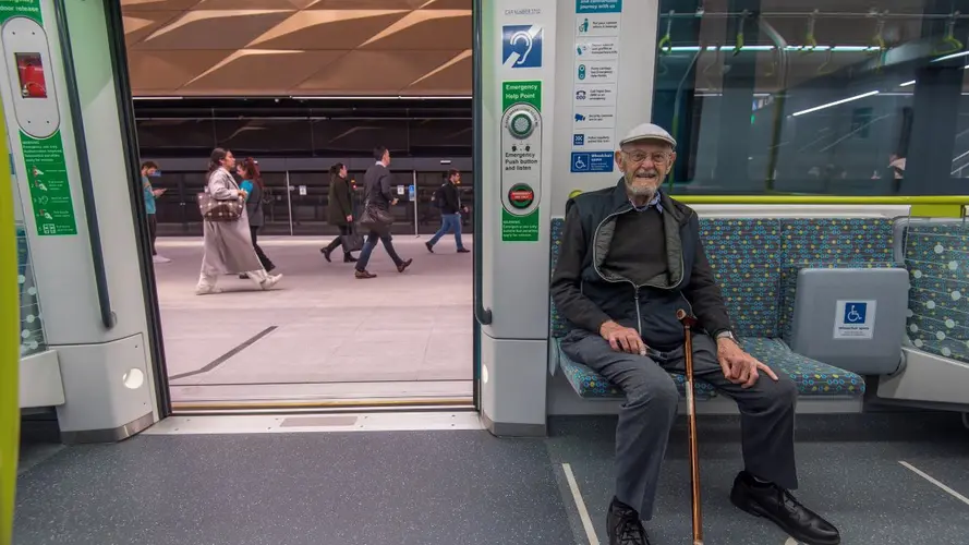 an elderly passenger sitting at the newly opened city line metro