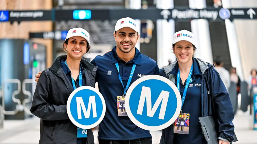 Metro employees holding two M logos