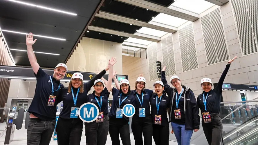 Sydney Metro employees at the City stations opening holding the M logo