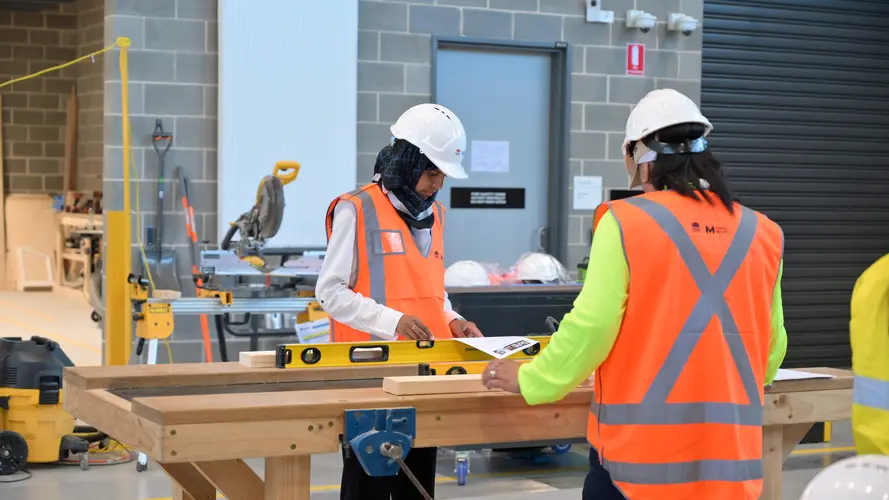 two women are working at the construction site workshop