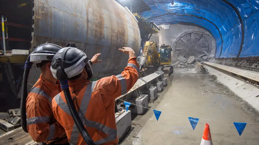 TBM Betty breakthrough under the tunnel where two workers are talking